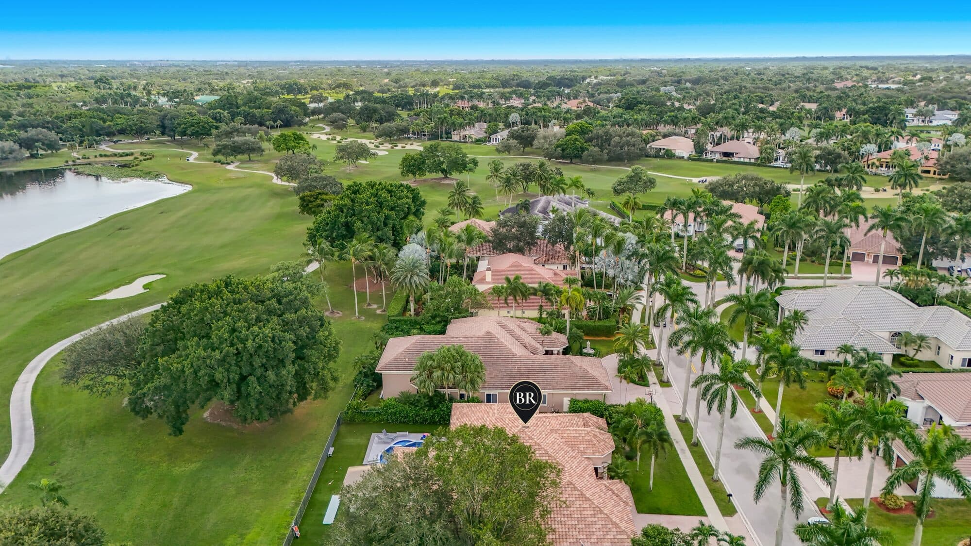 High aerial showing the home on the Tour Course fairway with the lake beyond