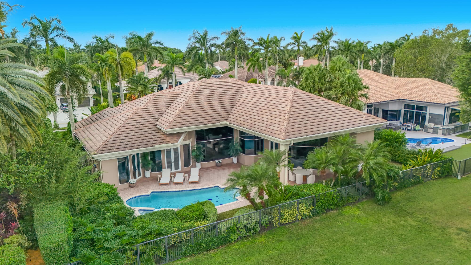 Aerial of the rear of the home, heated pool and golf-course frontage