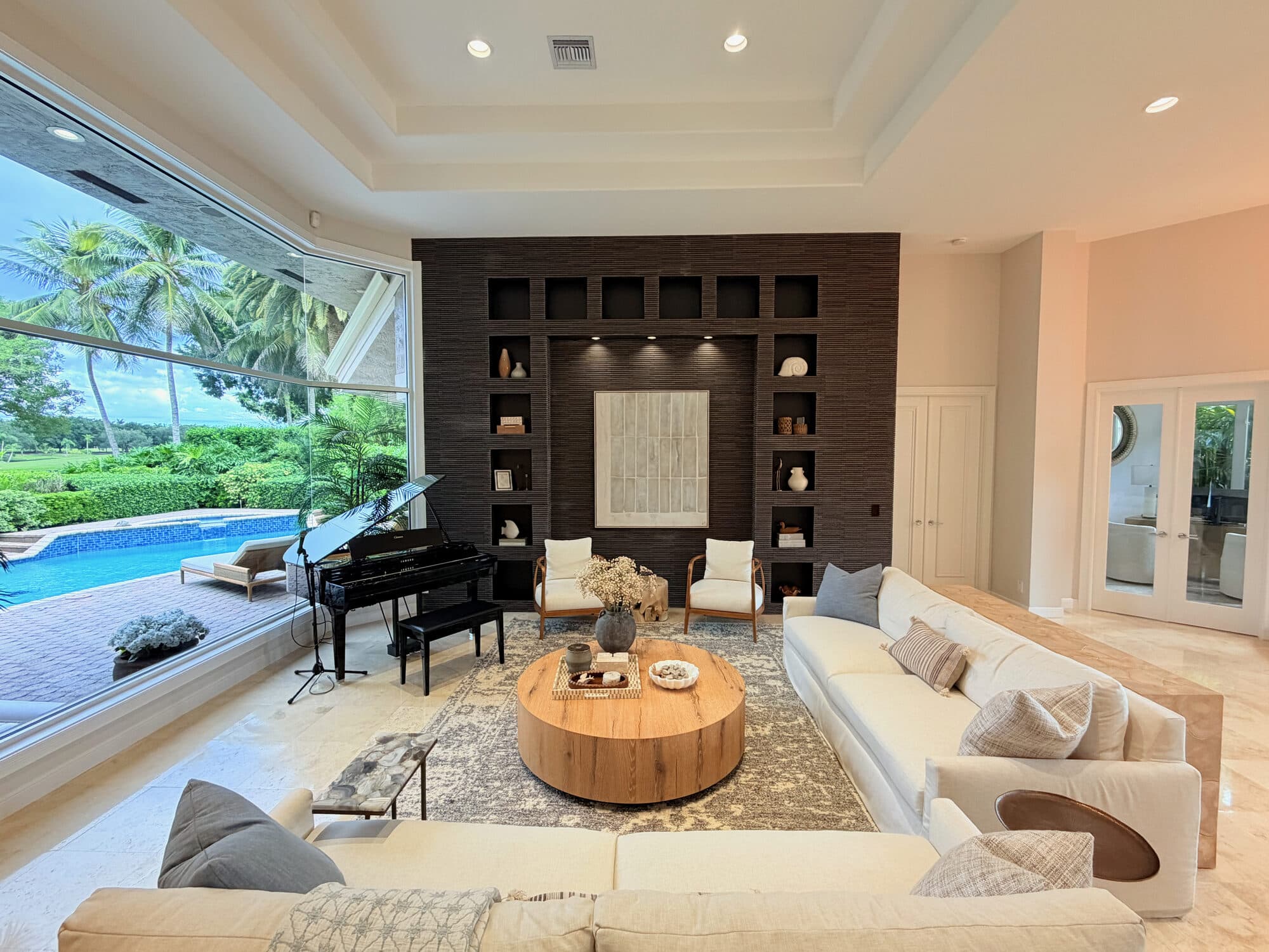 Living room with built-in feature wall and panoramic pool windows